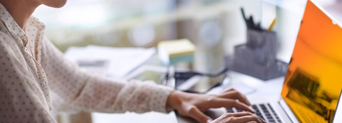 Kvinde, der arbejder på en bærbar computer med 3M™ Gold-databeskyttelsesfilter

