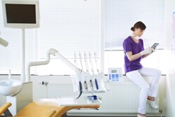 Tandlæge, der bruger en tablet-enhed