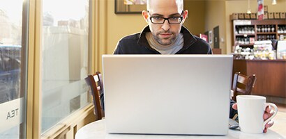 Person, der arbejder med en bærbar pc på et offentligt sted
