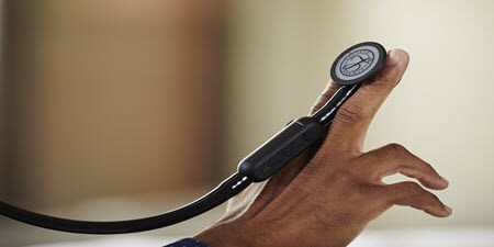 Et nærbillede af et Littman CORE digitalt stetoskop, der hviler på en persons fingre.
