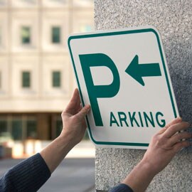 Person, der monterer et parkeringsskilt på en betonmur