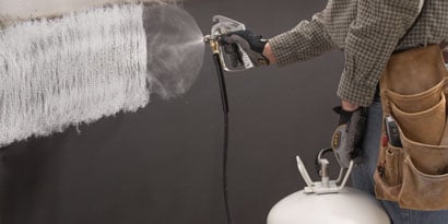 Person, der sprayer lim på med applikator
