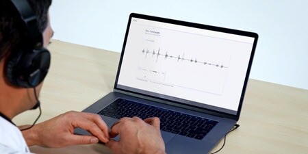 Kliniker, der bruger en bærbar computer til at kigge på den live telemedicinske auskultationsvideo
