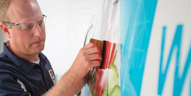 Mand installerer en grafisk film
